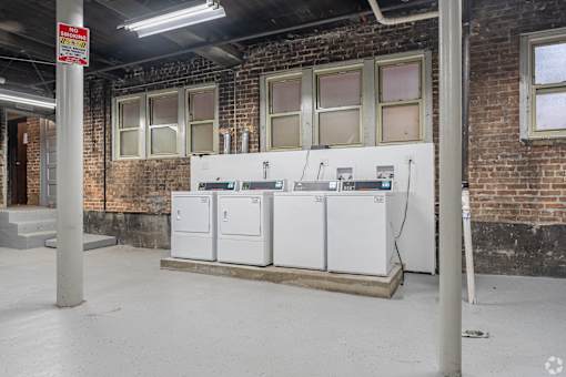 A large industrial freezer unit sits in a room with brick walls.