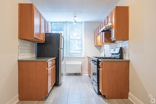 A kitchen with wooden cabinets and black appliances.
