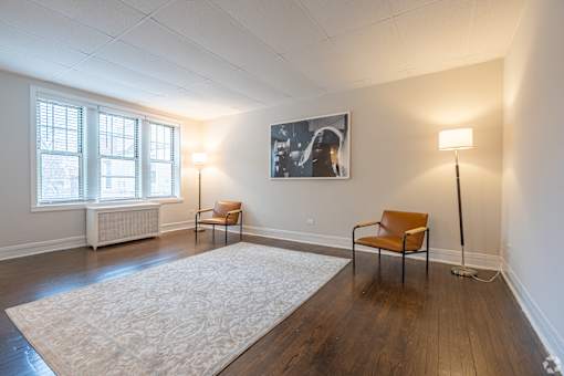 A room with a chair and a painting on the wall.