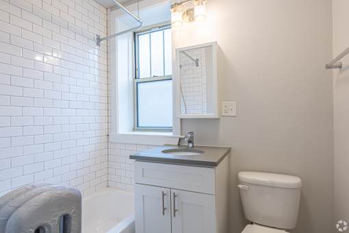 A white bathroom with a toilet, sink, and tub.
