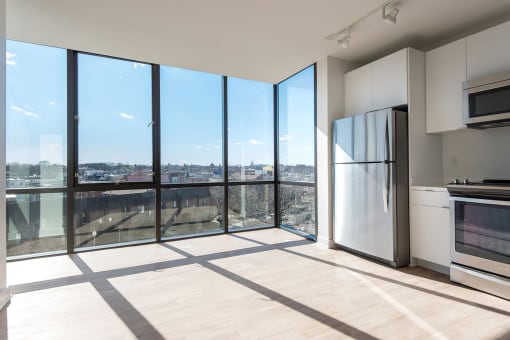 a kitchen with a large window and a door that leads to a balcony