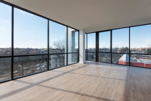 a living room with floor to ceiling windows and a wooden floor