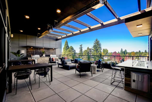 A modern outdoor kitchen with a view of the forest.