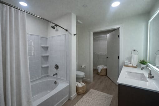 A bathroom with a white tub and sink.