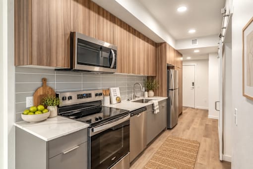 A modern kitchen with wooden cabinets and stainless steel appliances.