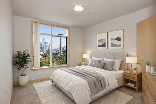 A bedroom with a large bed, a potted plant, and a city view through the window.