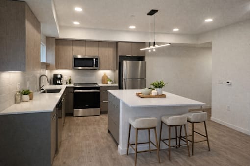 A modern kitchen with a bar area and stools.