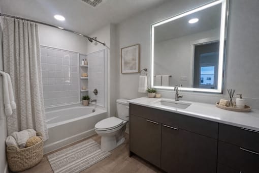 A bathroom with a white toilet, a sink, and a large mirror.