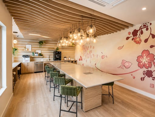 A kitchen with a long table and chairs.