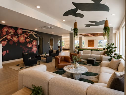 A living room with a large sofa set and a floral wallpaper.