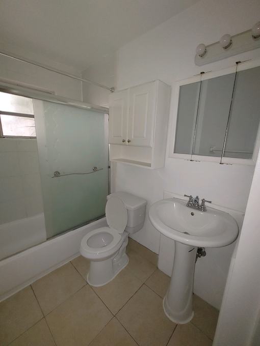 A white toilet and sink in a small bathroom.