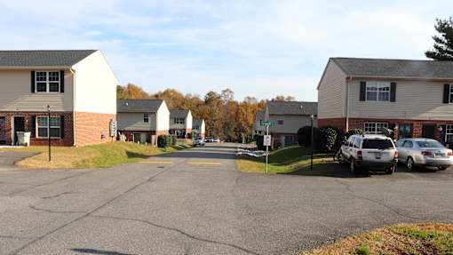 A parking lot with cars and apartment buildings in the background.