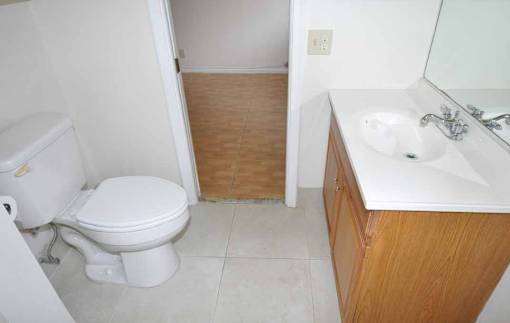 A white toilet is next to a sink in a small bathroom.