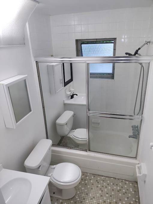 A white toilet and sink in a small bathroom.