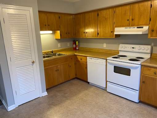 A kitchen with wooden cabinets and white appliances.