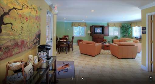 A living room with a painting on the wall and a television.