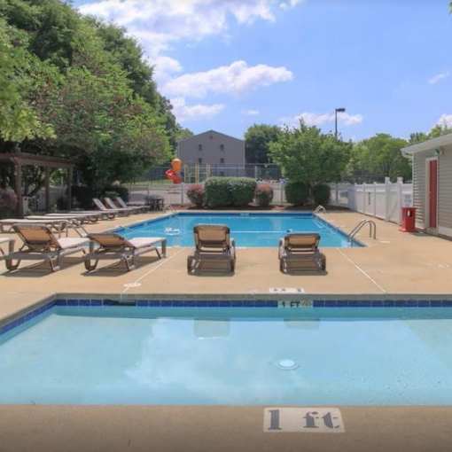 A pool with a blue tiled edge and a white sign on the ground.