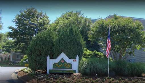 A sign that says "Maple Ridge" is in front of a house.