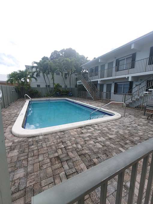 A small rectangular pool with a white border and a metal railing around it.