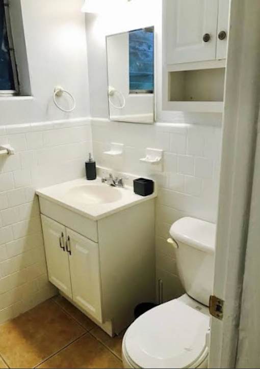 A white toilet sits next to a sink in a small bathroom.
