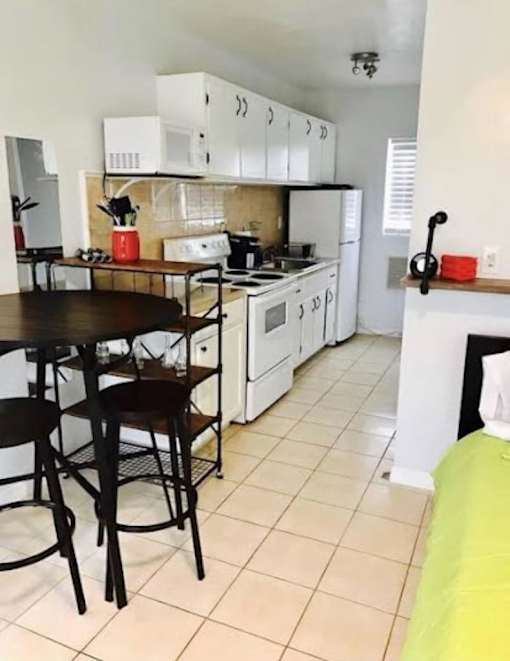 A kitchen with white cabinets and a black table.