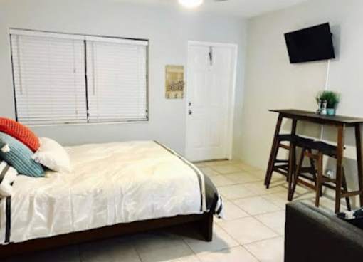 A bedroom with a bed, a chair, and a television.
