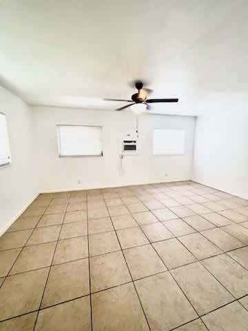 A room with a ceiling fan and tile flooring.