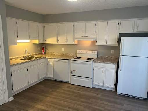 A kitchen with white appliances and cabinets.