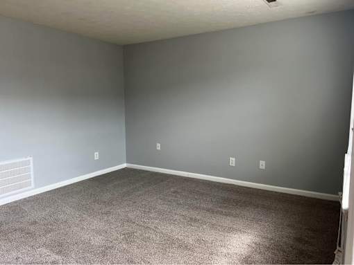 A room with grey walls and carpeted floor.