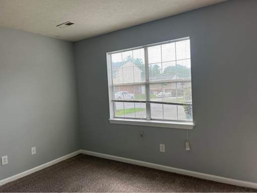 A room with a window and a ceiling fan.