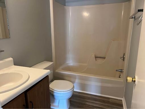 A white toilet sits next to a sink in a bathroom.
