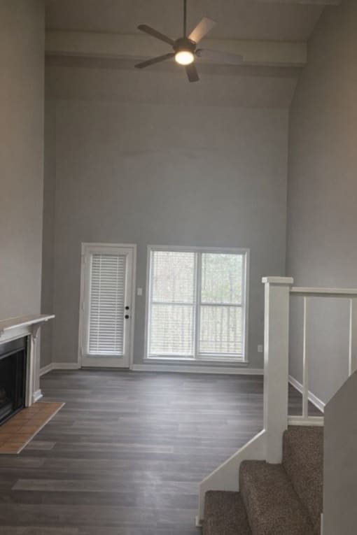 A room with a fireplace and a staircase.