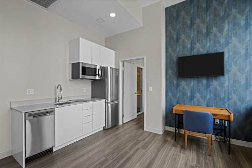 A modern kitchen with a blue patterned wallpaper.