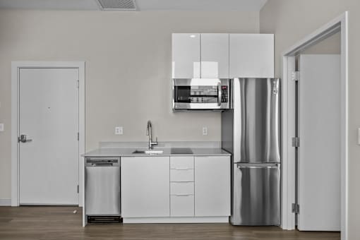 A modern kitchen with white cabinets and stainless steel appliances.