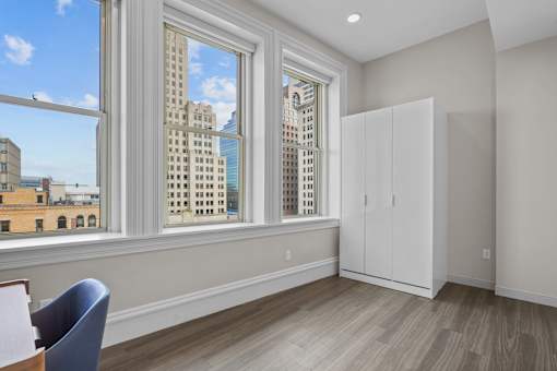 A room with a large window overlooking a cityscape.