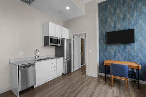 A modern kitchen with a blue patterned wallpaper and a wooden table.