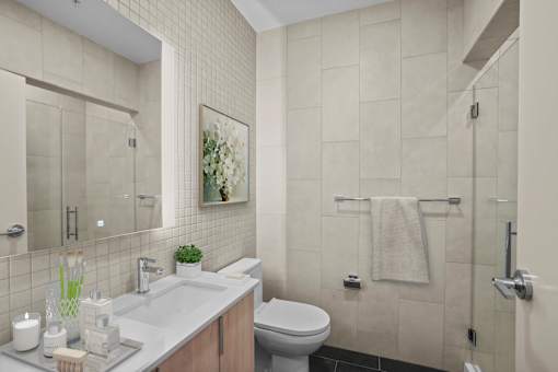 A bathroom with a toilet, sink, and a mirror.