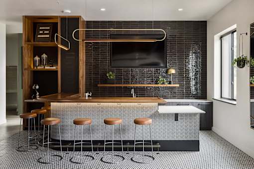 A modern kitchen with a bar area and stools.
