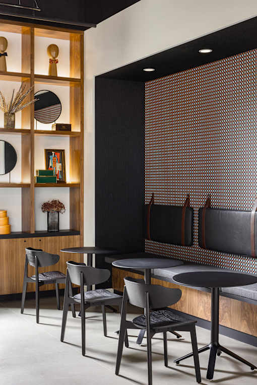 A black and white dining room with a wooden shelf and chairs.