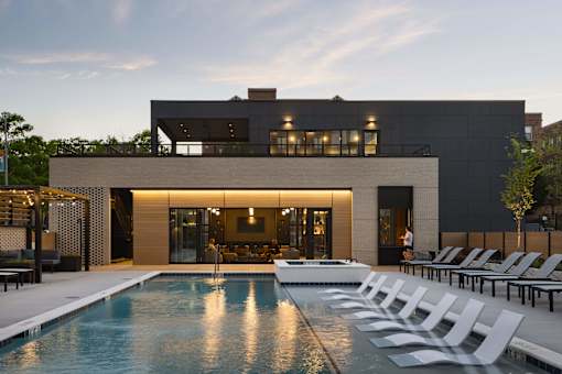 A modern house with a pool in front.