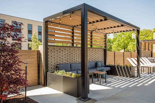 A patio with a table and chairs under a pergola.