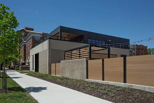 A modern building with a black facade and wooden fence.