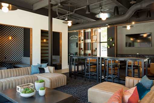 A modern living room with a sofa, coffee table, and a bar area.