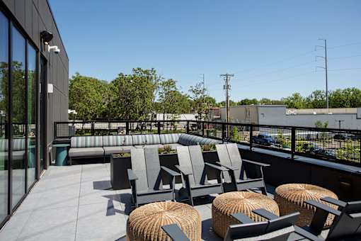 A patio with grey chairs and tables.