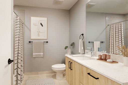A bathroom with a toilet, sink, and a mirror.