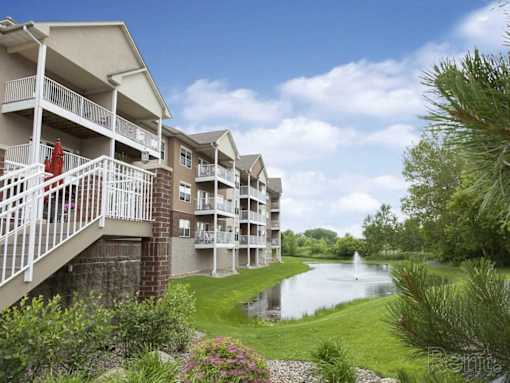 Apartment complex with a pond in the front.