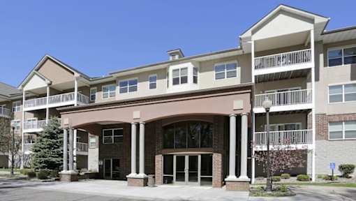 A large apartment building with a covered entrance and balconies.