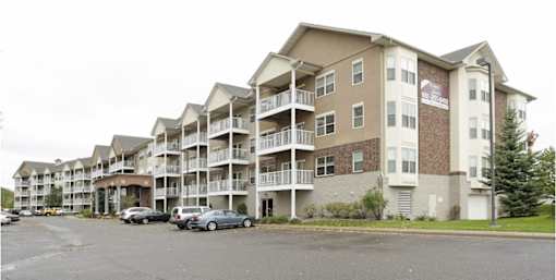 Apartment building with cars parked in front.