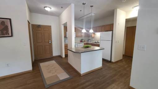 A kitchen with a white island and wooden floors.