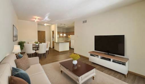 A living room with a white couch, a brown coffee table, and a flat screen TV.